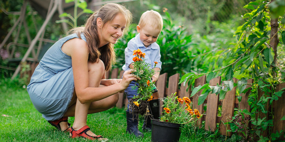 Pine Hills Nursery-Mississippi- How to Design a Kid Friendly Garden-mother and child planting marigold flowers